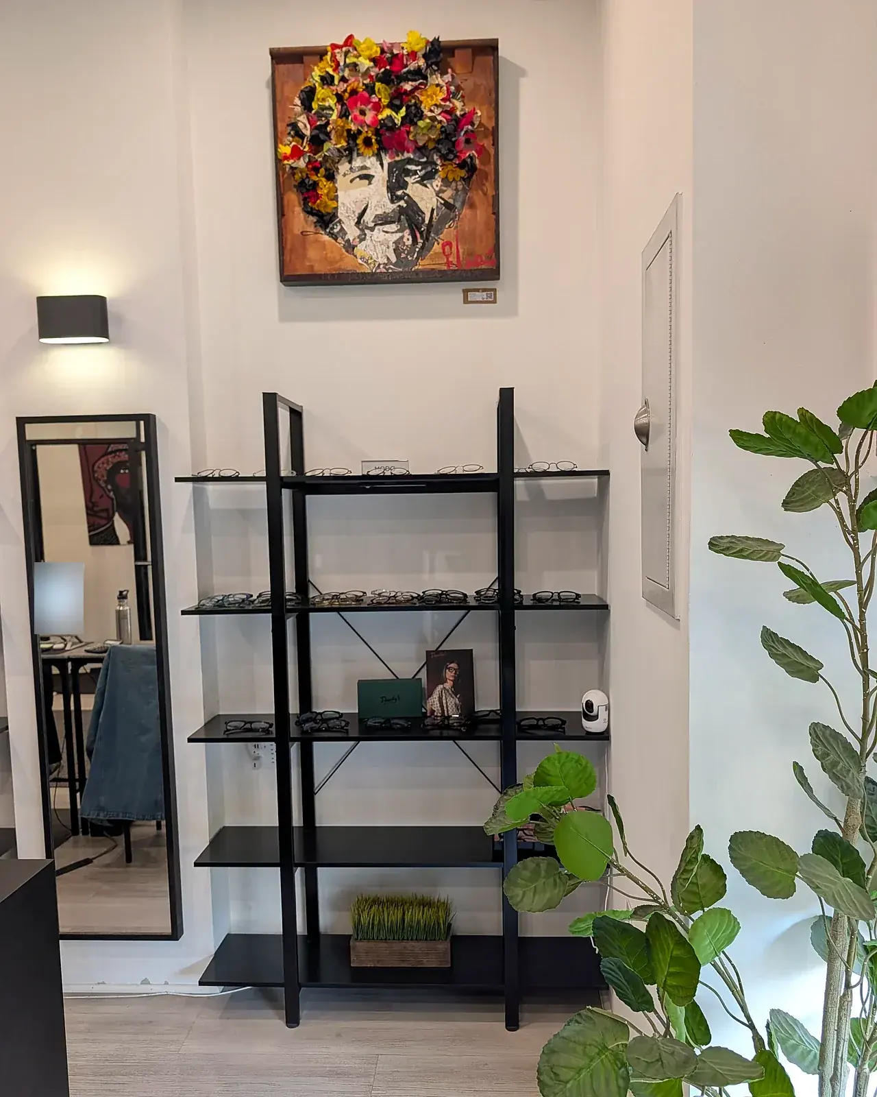 Eyeglass frames on display beneath colorful artwork in the Park Slope Eye optical
