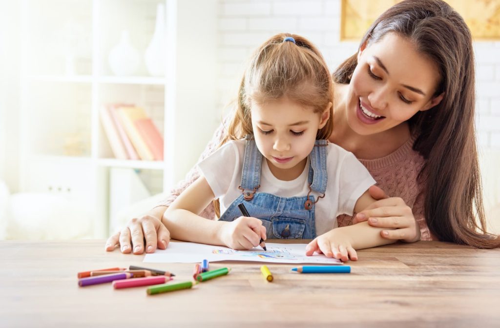 Mother and daughter coloring with pencil crayons