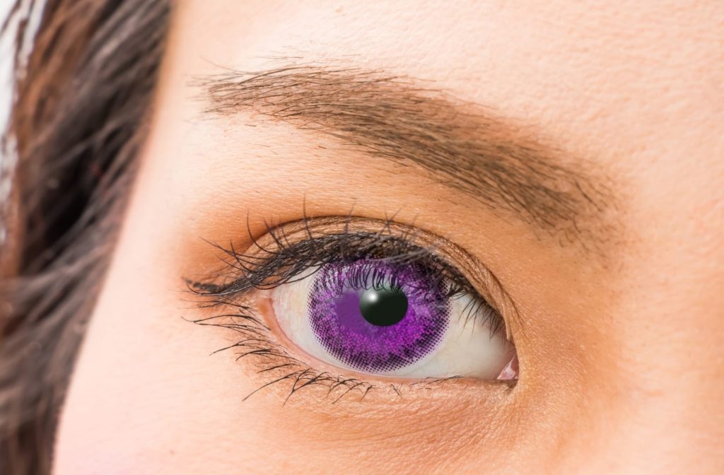 A woman wear violet colored contacts that are safe to wear if obtained with a prescription from her eye doctor