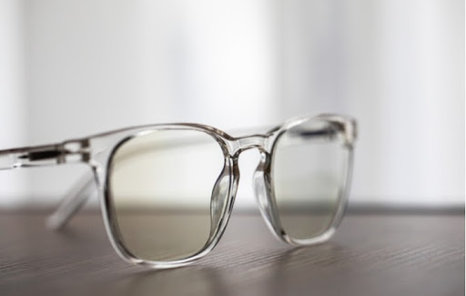 A pair of translucent glasses sitting on a wood surface