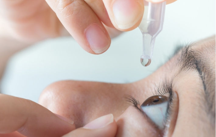A person putting in artificial tears for their dry eye