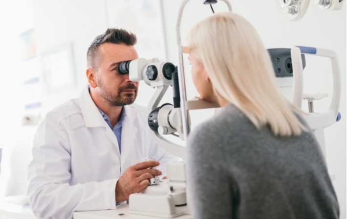 A woman at her optometrist getting an eye exam to check up on her ocular health