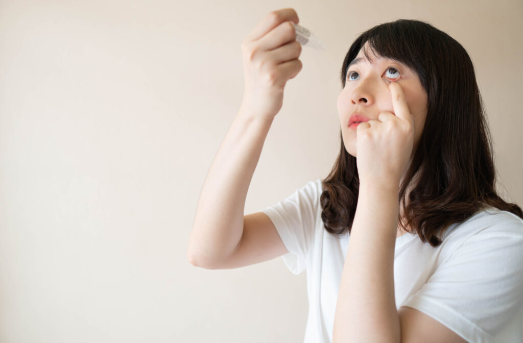 A woman pulling her lower eyelid down to help her apply eye drops properly.